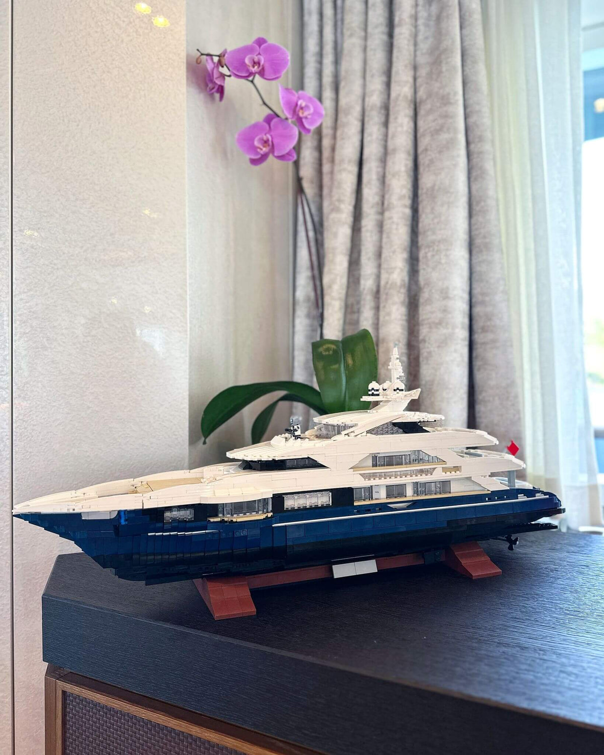 Modelo de ladrillos personalizado de un yate expuesto sobre un aparador